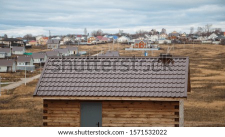 the roof of the house of tiles utility room on the background of the village under construction