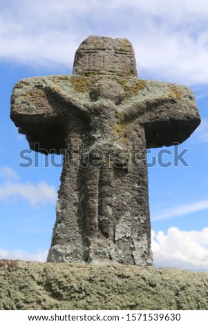 Picture of a many hundred years old stone cross in an old cemetery