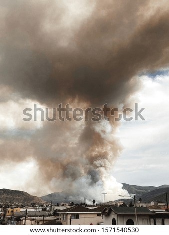 Fire on the mountains with a big column of smoke. Ensenada. baja California. Mexico.