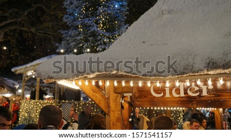 Christmas Market huts at night with artificial snow in London, United Kingdom.