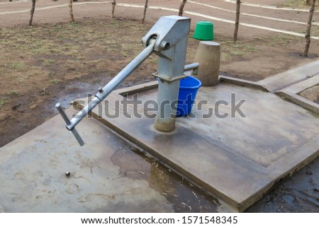 Hand pump for clean water in rural Malawi Royalty-Free Stock Photo #1571548345