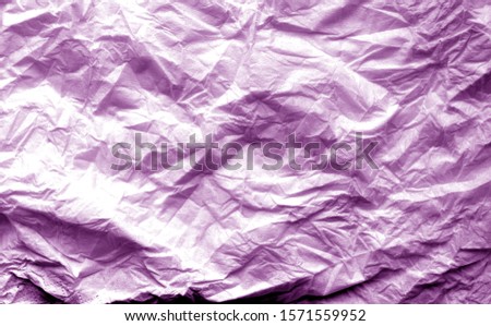 Crumpled sheet of paper with blur effect in purple tone. Abstract background and texture for design.