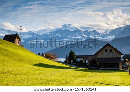 small mountain village and snowy peaks of Alps in the background