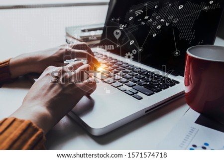 Businessman using laptop computer with Digital marketing media and virtual globe shape diagram. Business Financial icons graphs.