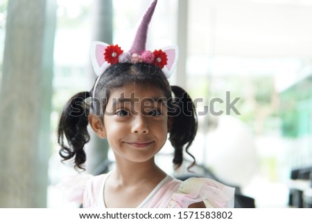Young beautiful girl dressing up as a princess with a unicorn hat. 