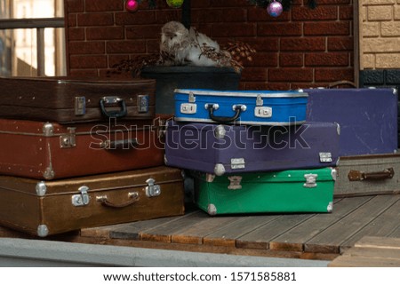 many suitcases are stacked on top of each other. Suitcases on a cart near a brick wall. Concept, preparation for the trip.