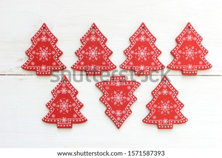 Christmas background. Small red Christmas trees on a white background white snowflakes, a symbol of Christmas.