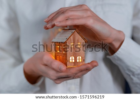 concept technology protection of the house from the cold. house in caring female hands Royalty-Free Stock Photo #1571596219