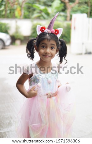 Young beautiful girl dressing up as princess with unicorn hair band feeling excited but also anxious waiting for dentist appointment.