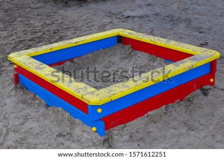 Children's multi-colored sandbox made of wood