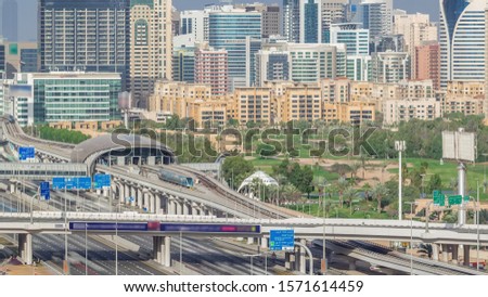 Dubai Golf Course with a cityscape of Gereens and tecom districts at the background aerial timelapse. Traffic on sheikh zayed road with junction and metro starion