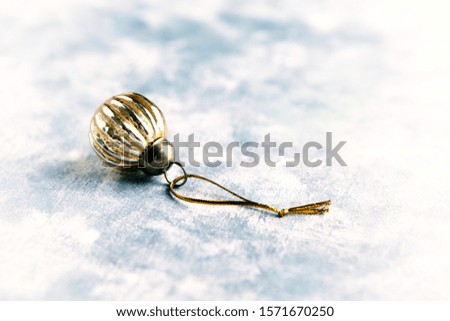 Christmas golden bauble on bright wooden background. Close up. Copy space. 