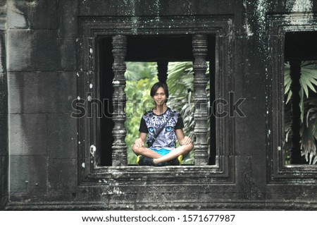 A selective shot of a male wearing a tiger print shirt doing yoga