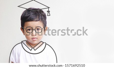 Asian kid 2 year old. Imagination his graduated day with hand drawn graduate dress on white background, education and graduation concept idea.                                                          