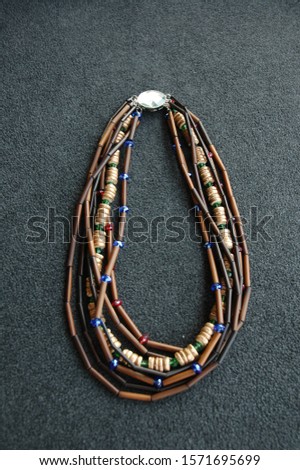 A vertical shot of a necklace made of colorful beads on a gray surface
