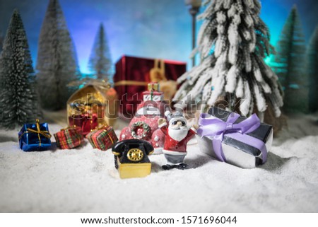 Christmas and New Year holidays concept. Little decorative cute small red car in snow at night. Traditional holiday attributes on snow. Creative artwork decorations. Empty space for your text
