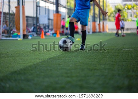 Children playing control soccer ball tactics on grass field with for training background Training children in Soccer