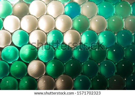 Macro of hydrogel. Bright green round gel balls of green turquoise color. Abstract bright background