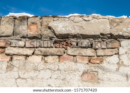 Crumbling brick wall close-up against the sky