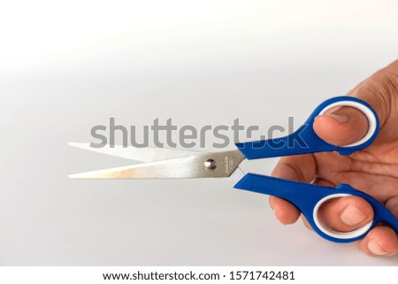 Hand hold blue scissors isolated on white background.