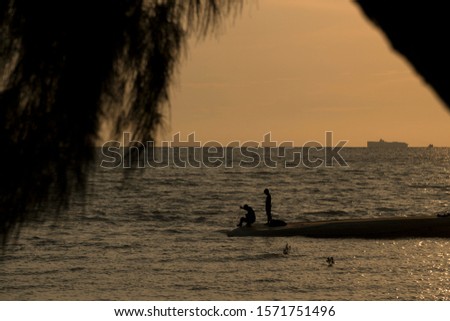 Beautiful sunset nature background,fisherman with net fish on beach. Father and son fishing. Family bond concept.