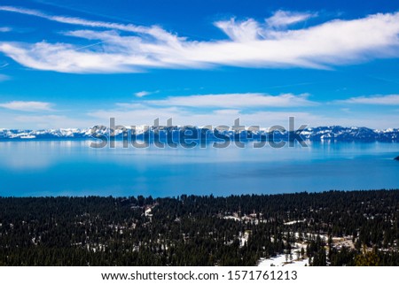 a lake with reflections from the mountains with snow