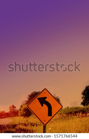 A vertical shot of a turn sign with a blurred background