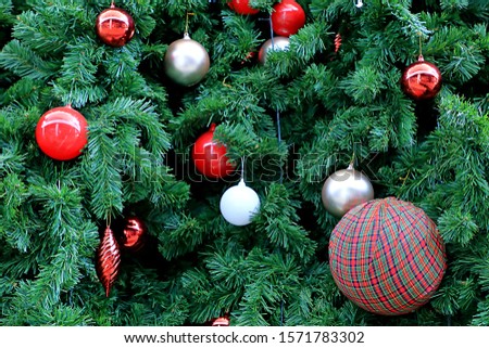 Red tartan pattern big ball decorated on Christmas tree.