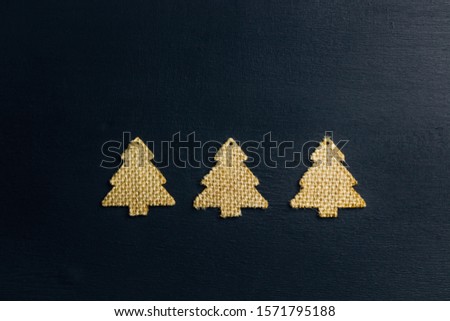 Christmas or New Year composition on black background with wooden decorations trees. Zero waste. Flat lay. Copy space. Top view