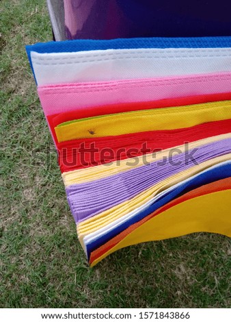 isolated Rainbow Colors of Non Woven Fabric Bags on Green Grass