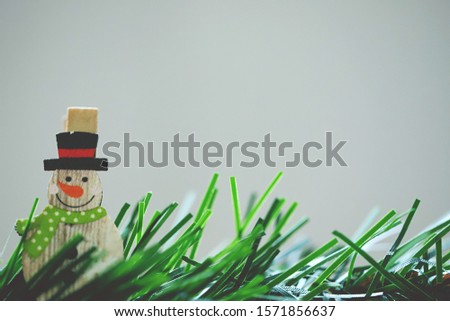 Wooden snowman and green pine leaf tree decoration in Christmas closeup blur texture background