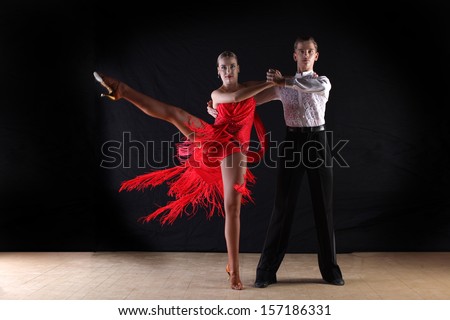 dancers in ballroom against black background