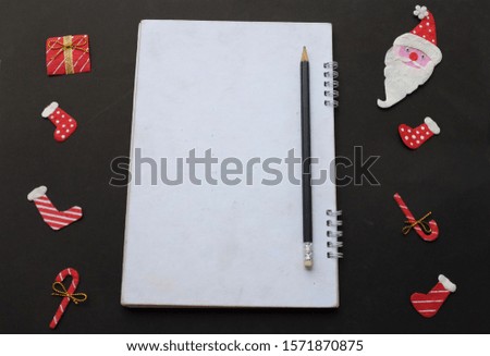 flat lay an close up White notebook with Christmas and New Year decorations on black background