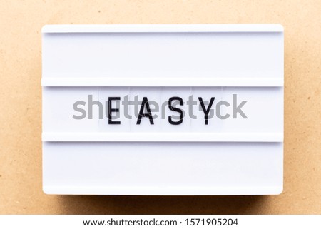 Lightbox with word easy on wood background