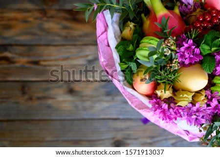 the process of forming a fruit and flower bouquet. tutorial, do it yourself. photo 39,  finished bouquet is in a vase on a wooden background. top view, space for text