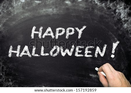 Conceptual happy Halloween ad on black chalkboard.