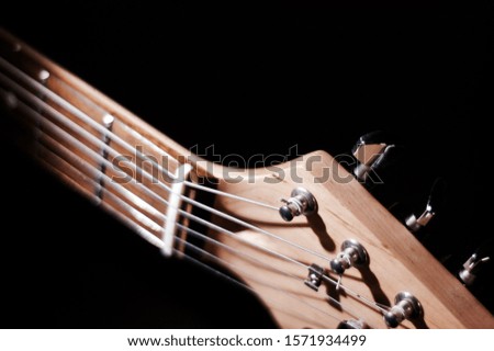 electric guitar headstock closeup . dark background