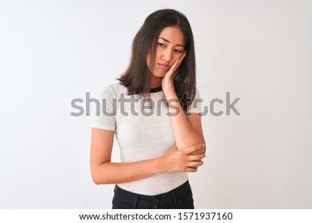 Young beautiful chinese woman wearing casual t-shirt standing over isolated white background thinking looking tired and bored with depression problems with crossed arms.