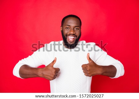 Portrait of positive cheerful dark skin man show thumb up select suggest ads promo wear good look clothes isolated over red color background