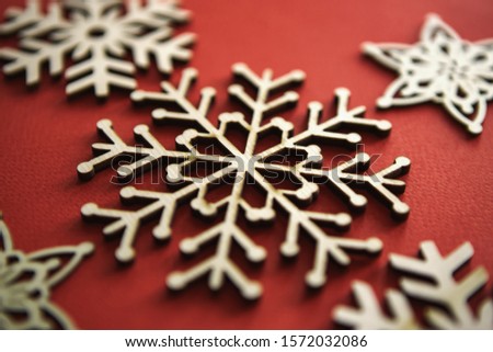 Handmade Christmas snowflake toy on red background.Hand made wooden crafts for home decoration in winter holiday season.Rustic snowflakes for New Year decorations,edited with vintage style film filter