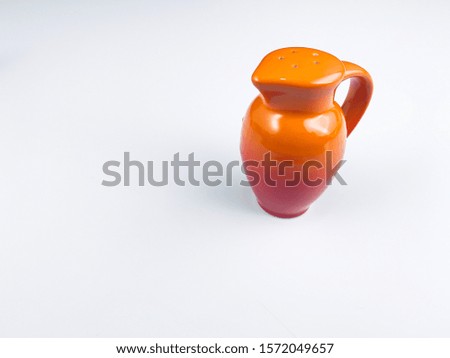 Small orange ceramic jug With a small hole above used for containing food utensils Tableware decoration prop for taking pictures on a white background.