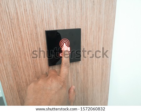 Man hand pressing exit button to open a door on a modern office 