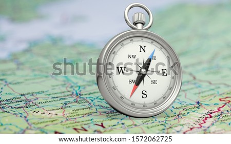 Magnetic compass  and location marking with a pin on routes on world map Royalty-Free Stock Photo #1572062725
