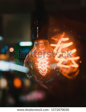 A vertical closeup shot of turned-on light bulbs with interesting textures on a blurred background