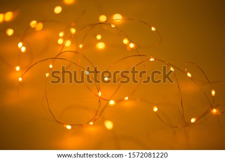Christmas lights on yellow background with copy space. Decorative garland