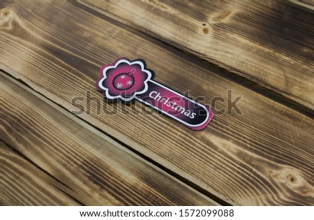 Red sticker with Christmas illustration on wooden background