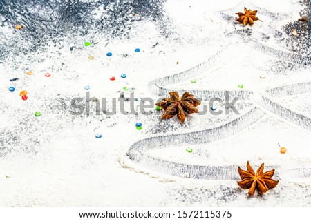 Christmas flat lay composition. Christmas tree painted of flour on a dark background. Christmas, winter holidays, new year concept. Copy space for text.