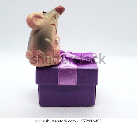 The rat is a symbol of the new year 2020 is sitting near the present box. New year mood.Christmas card. Happy New Year.