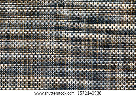 Close-up of black and orange synthetic fabric texture. membrane fiber structure. weaving pattern of interwoven fibers. fiber braided background.