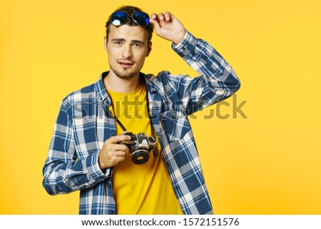 A man holding a checkered shirt camera travel vacation flight